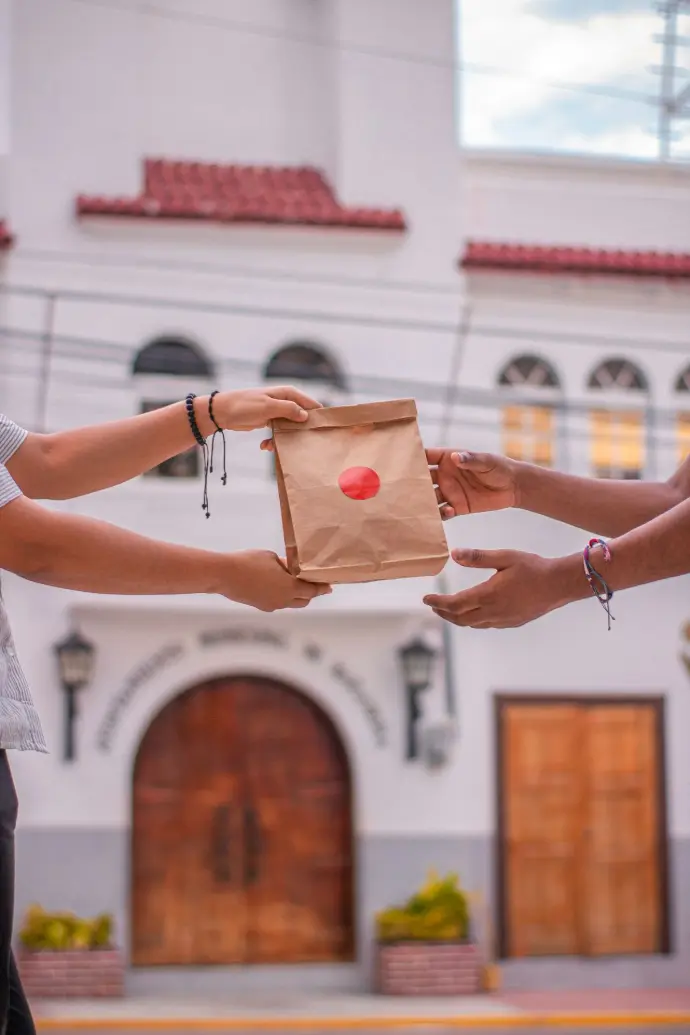 A couple of people that are holding a brown bag